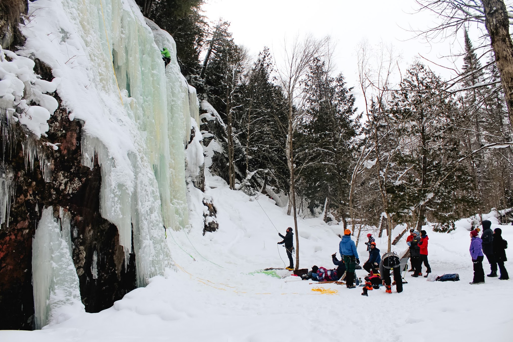 Ice Fest 2025 - a group cheering on an ice climber at Searchmont Ice Wall